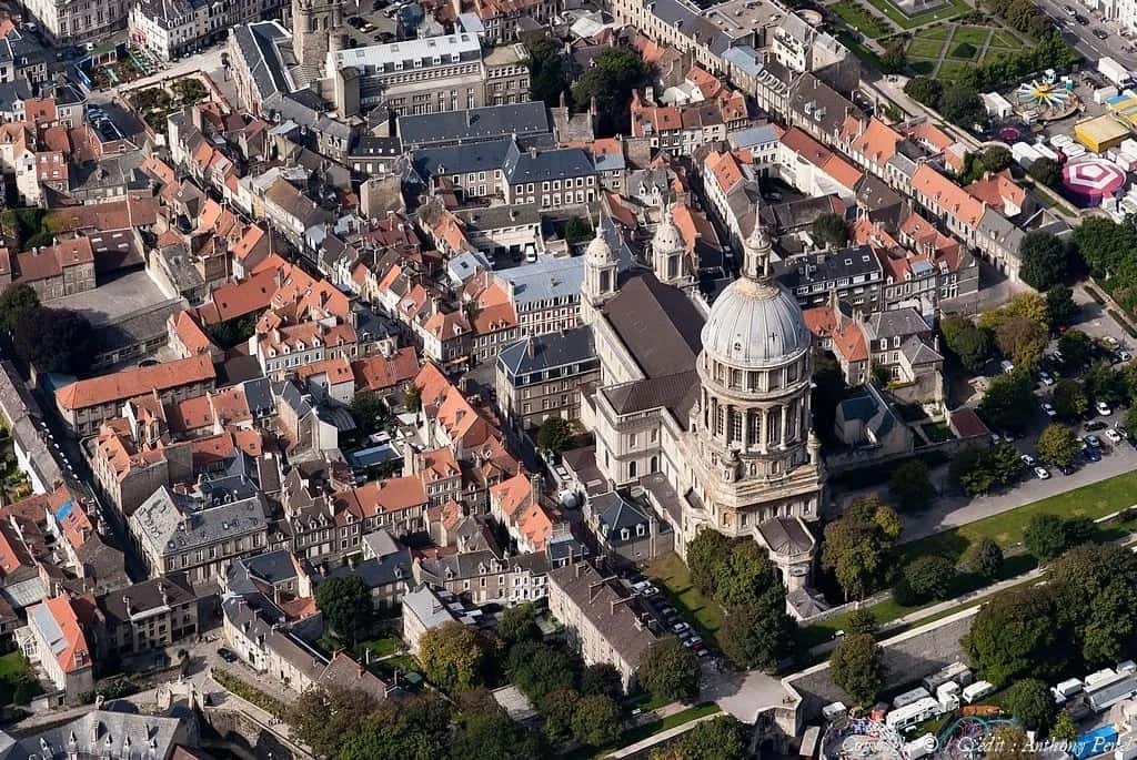Vue aérienne d’une ville avec une grande cathédrale et des toits rouges.